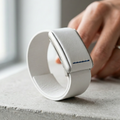White smartwatch on a concrete surface with a blurred background